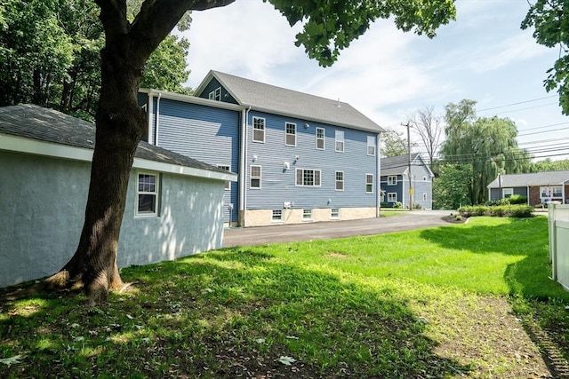 back of house featuring a lawn