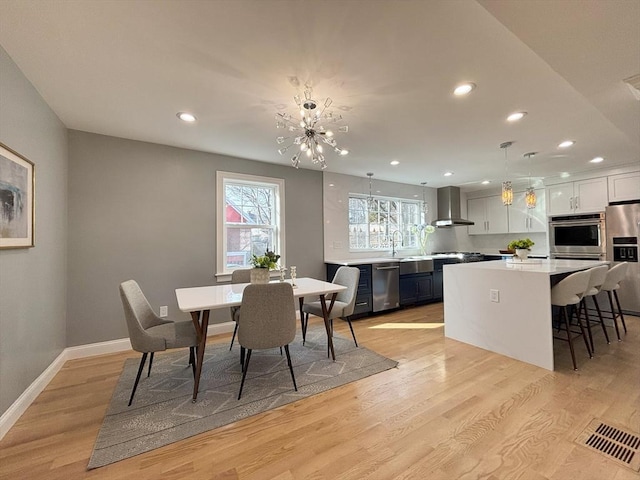 dining space featuring recessed lighting, baseboards, and light wood finished floors