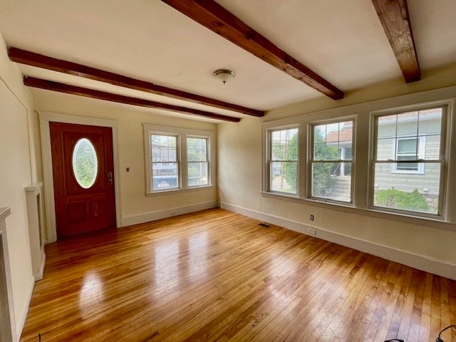 foyer entrance featuring beamed ceiling and light hardwood / wood-style floors