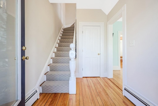 113 Taylor St Unit 1, Waltham, MA 02453 - foyer entrance with stairs, baseboards, light wood finished floors, and a baseboard heating unit