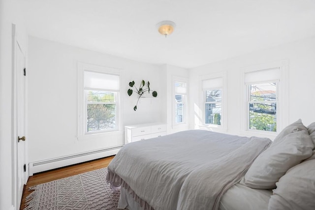 113 Taylor St Unit 1, Waltham, MA 02453 - bedroom with a baseboard heating unit, multiple windows, and wood finished floors