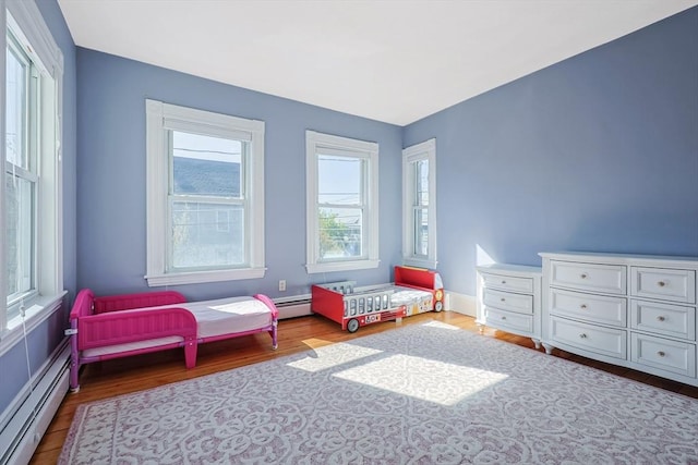 113 Taylor St Unit 1, Waltham, MA 02453 - bedroom with wood finished floors and a baseboard heating unit