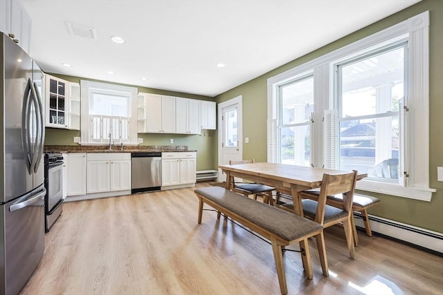 113 Taylor St Unit 1, Waltham, MA 02453 - kitchen with white cabinets, stainless steel appliances, a sink, and light wood finished floors