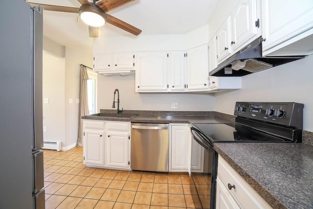 kitchen featuring dark countertops, a baseboard heating unit, under cabinet range hood, a sink, and appliances with stainless steel finishes