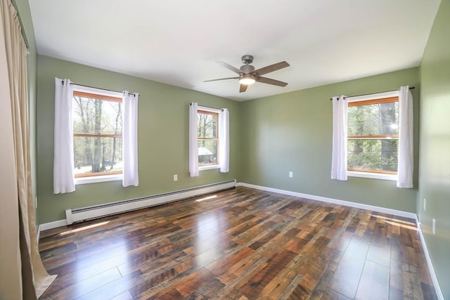 spare room featuring baseboard heating, hardwood / wood-style floors, and a wealth of natural light