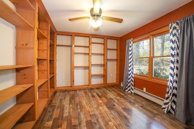 interior space featuring dark wood finished floors, ceiling fan, and a baseboard heating unit