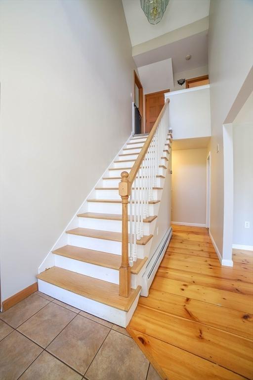 stairs with baseboards and a baseboard radiator
