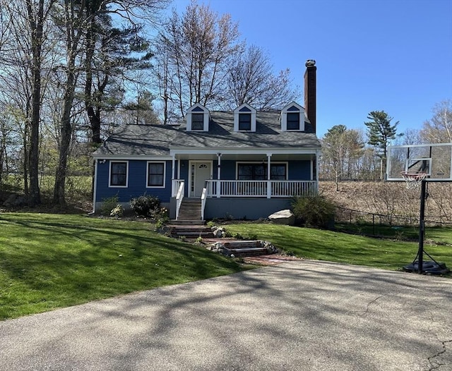 cape cod home with a porch, a chimney, and a front yard