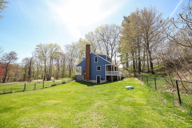 exterior space featuring a lawn, a chimney, and a fenced backyard