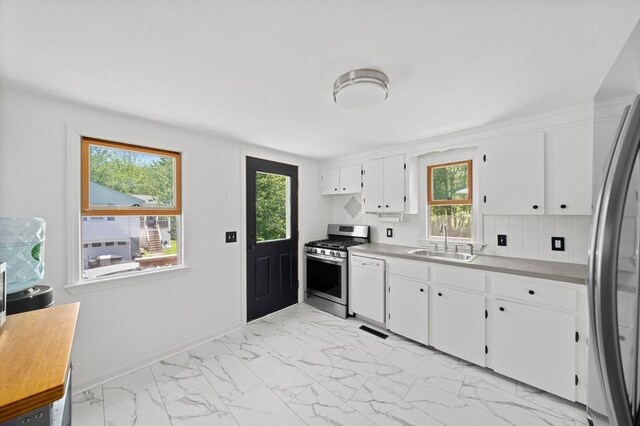167 Green St, Abington, MA 02351 - kitchen featuring appliances with stainless steel finishes, light marble finish flooring, white cabinets, backsplash, and light countertops