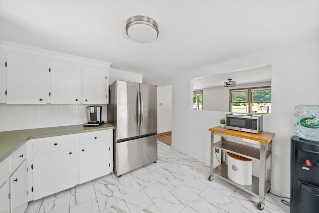 167 Green St, Abington, MA 02351 - kitchen with appliances with stainless steel finishes, light marble finish flooring, white cabinets, and backsplash