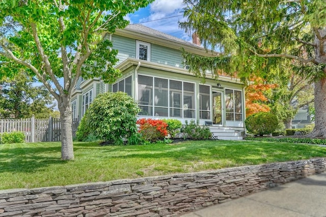 rear view of house with a sunroom and a chimney