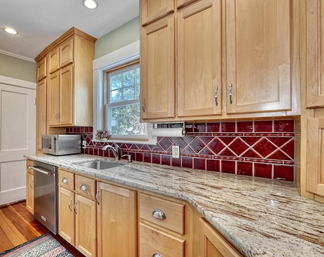 kitchen with stainless steel appliances, light brown cabinets, backsplash, a sink, and recessed lighting
