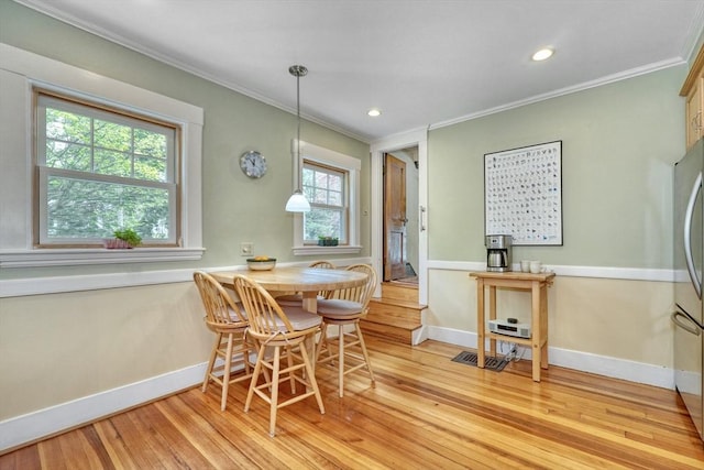 dining space with crown molding, light wood-type flooring, baseboards, and recessed lighting