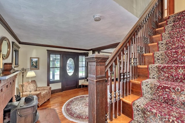 entrance foyer with light wood finished floors, stairway, ornamental molding, and baseboards