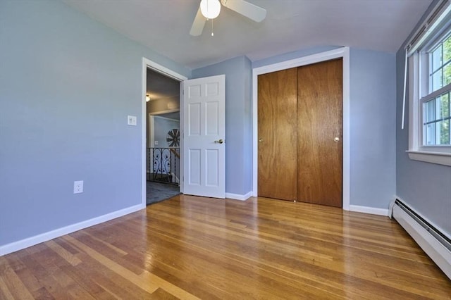 10 Locust St, Burlington, MA 01803 - unfurnished bedroom featuring a baseboard radiator, wood finished floors, a closet, and ceiling fan