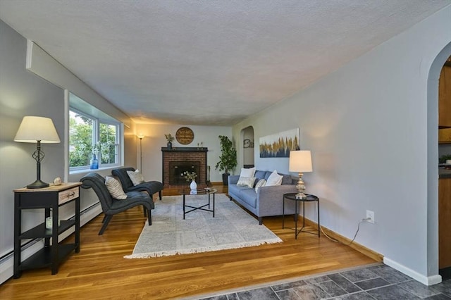 10 Locust St, Burlington, MA 01803 - living area featuring arched walkways, a fireplace, a textured ceiling, and wood finished floors