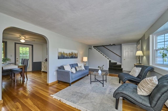 10 Locust St, Burlington, MA 01803 - living area with arched walkways, stairway, wood finished floors, and a textured ceiling