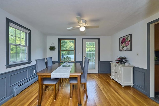 10 Locust St, Burlington, MA 01803 - dining space featuring baseboard heating, plenty of natural light, wainscoting, a decorative wall, and ceiling fan