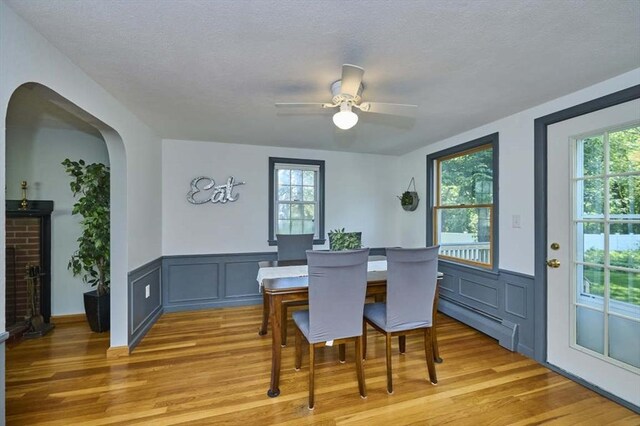 10 Locust St, Burlington, MA 01803 - dining area featuring a baseboard heating unit, light wood finished floors, a textured ceiling, healthy amount of natural light, and a wainscoted wall