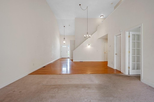 30 Horne Way Unit 30, Millbury, MA 01527 - unfurnished living room featuring high vaulted ceiling, carpet, a chandelier, baseboards, and wood finished floors