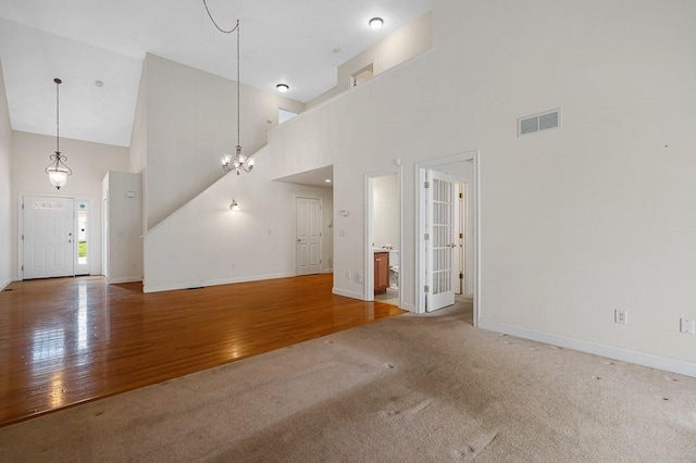30 Horne Way Unit 30, Millbury, MA 01527 - unfurnished living room featuring a high ceiling, baseboards, carpet, wood finished floors, and a chandelier