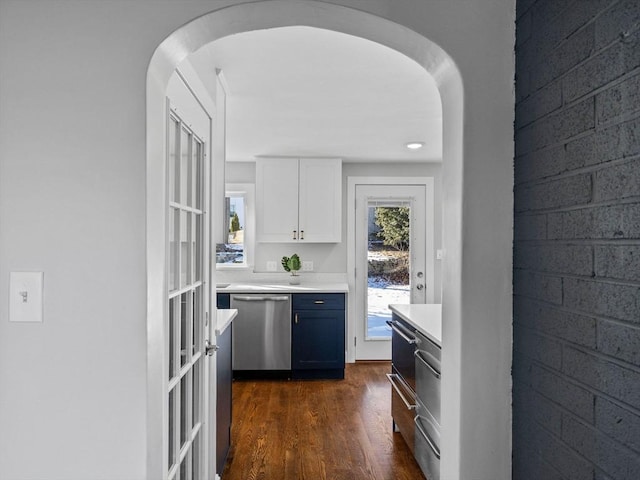 kitchen featuring white cabinetry, stainless steel dishwasher, and dark hardwood / wood-style floors