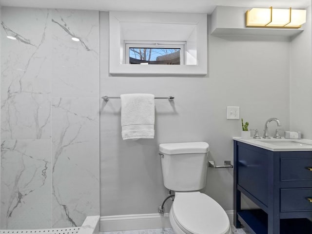 bathroom with vanity, toilet, and a tile shower