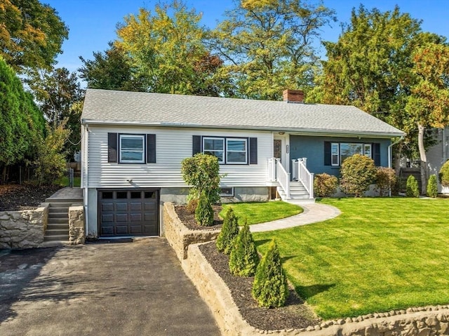 view of front of home with a garage and a front lawn