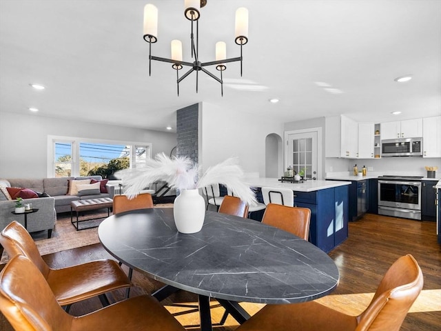 dining room with dark hardwood / wood-style flooring and a chandelier