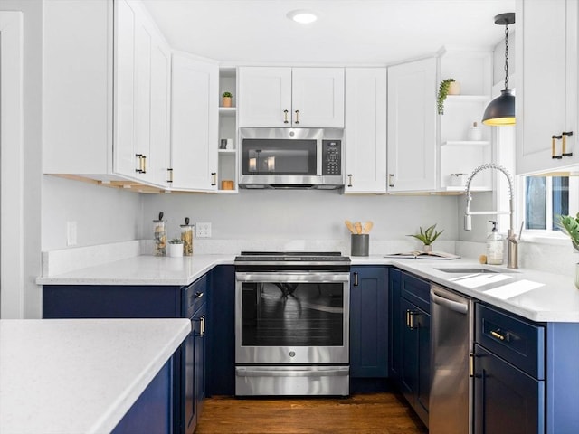 kitchen with blue cabinets, appliances with stainless steel finishes, pendant lighting, and white cabinets