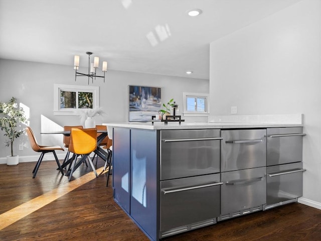 kitchen featuring dark hardwood / wood-style flooring, a chandelier, kitchen peninsula, and a wealth of natural light