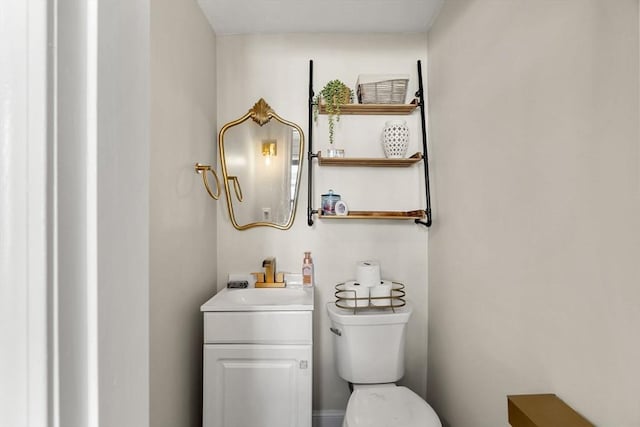 half bath featuring vanity and toilet