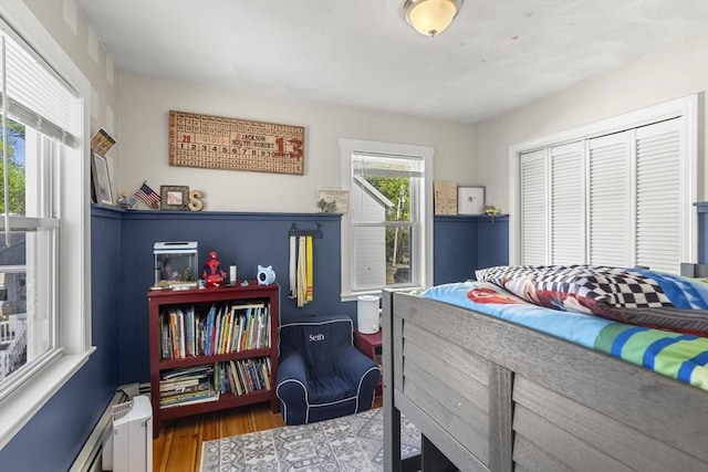 bedroom with wood finished floors and a closet