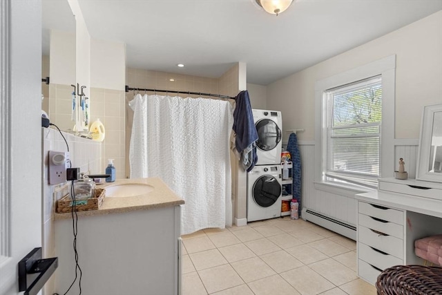 bathroom with tile patterned flooring, vanity, baseboard heating, a shower with curtain, and stacked washer / drying machine