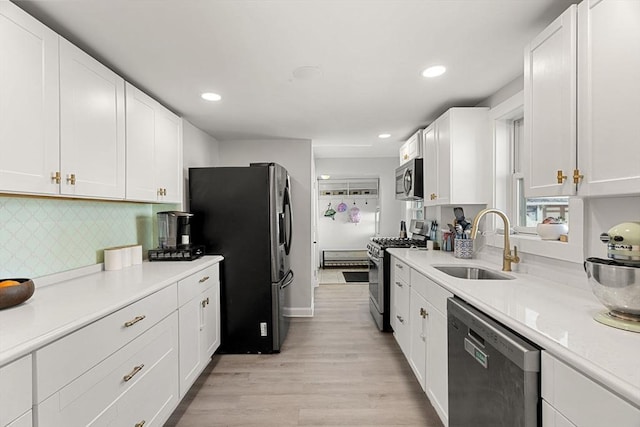 kitchen with a sink, appliances with stainless steel finishes, and white cabinets