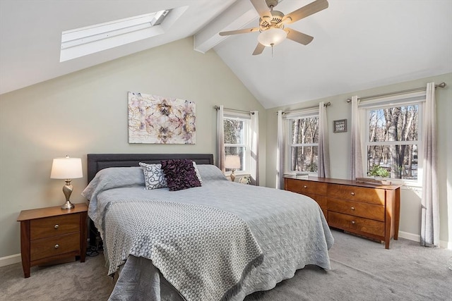 bedroom with lofted ceiling with skylight, light colored carpet, and ceiling fan