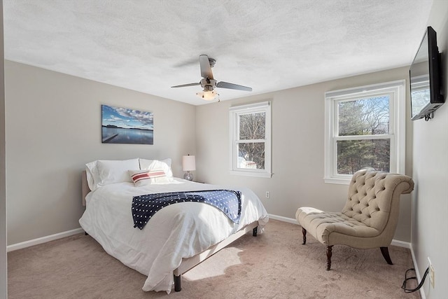 bedroom with light colored carpet, a textured ceiling, and ceiling fan