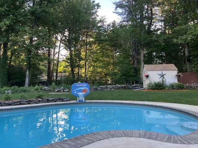 view of pool with a yard and a storage unit