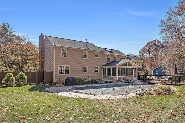 rear view of house with a patio, a yard, and a sunroom