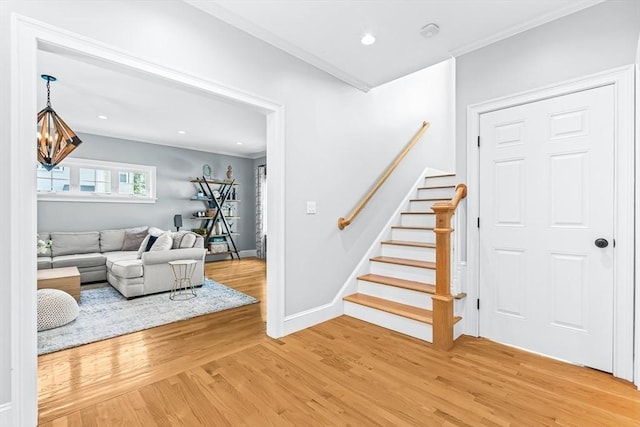stairs with wood finished floors, crown molding, recessed lighting, and baseboards
