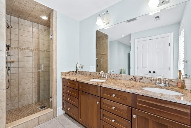full bathroom featuring a stall shower, tile patterned floors, and double vanity