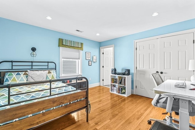 bedroom featuring wood finished floors, recessed lighting, a closet, and baseboards