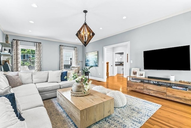 living room featuring ornamental molding, wood finished floors, recessed lighting, baseboards, and a chandelier