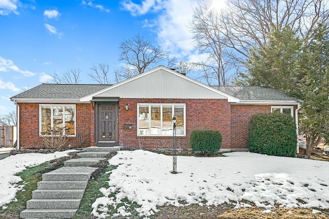 view of front of home with brick siding and roof with shingles