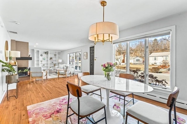 dining space featuring light wood-style floors and visible vents