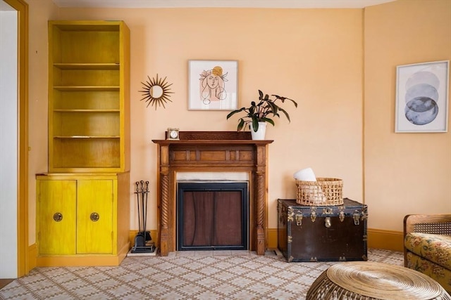 living area featuring built in features, baseboards, and a fireplace