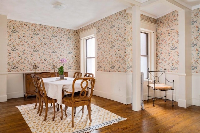 dining room featuring wood finished floors, wainscoting, and wallpapered walls