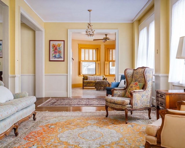 sitting room featuring plenty of natural light, wood finished floors, and a wainscoted wall