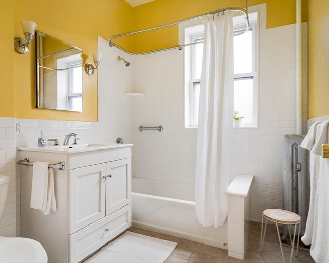 bathroom with tile patterned floors, toilet, tile walls, shower / tub combo, and vanity